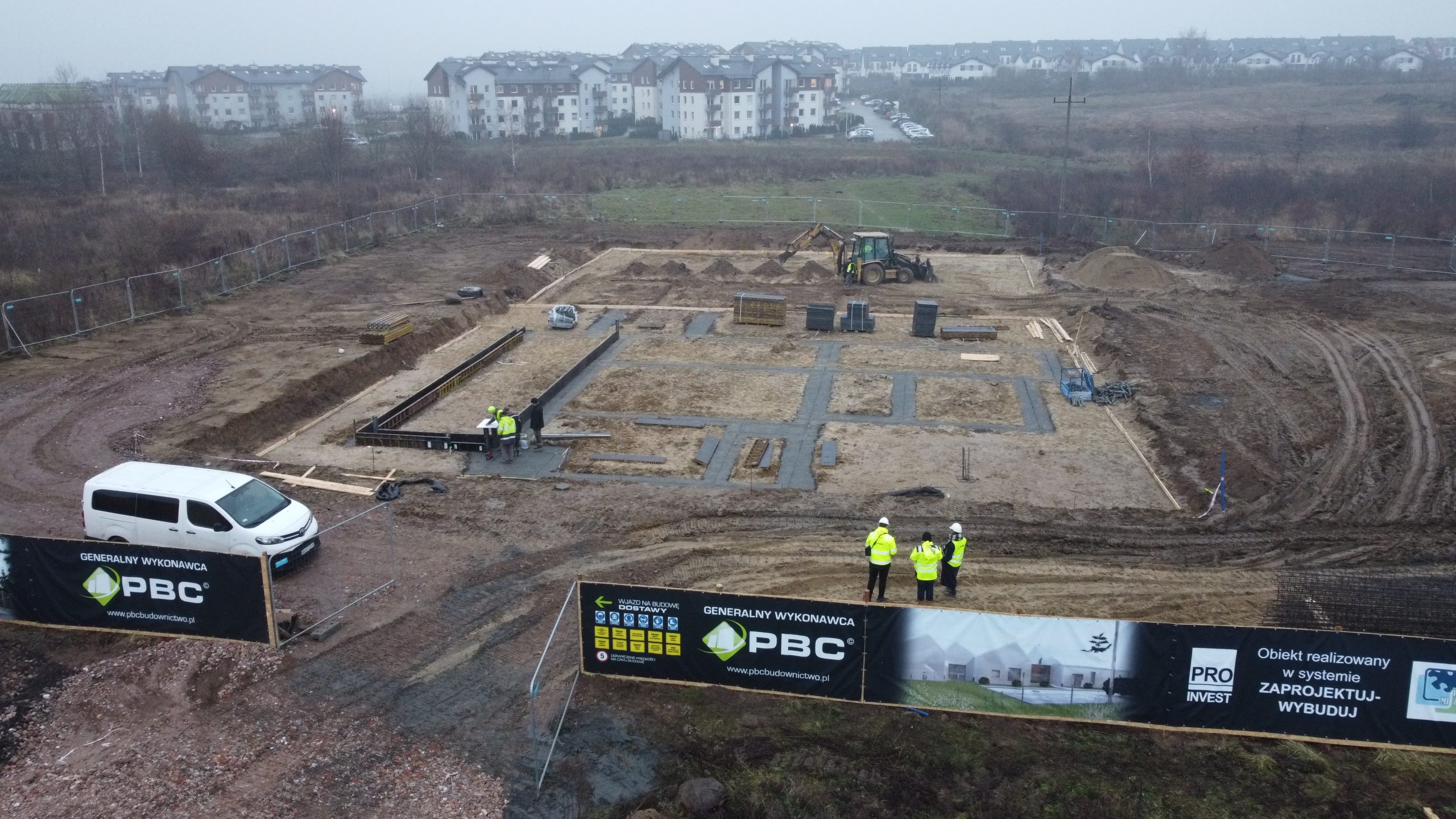 Plac budowy Pomorskiej Farmy Życia: fundamenty i koparka, widok z drona